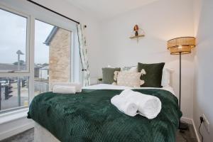 海尔Harveys Yard by Signature Stays - Hayle House - Parking - Sleeps 6的一间卧室配有绿床和毛巾