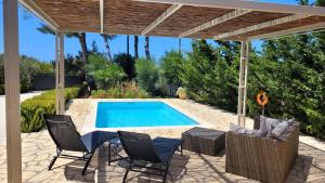 a patio with chairs and a swimming pool at Ponderosa Kefalonia in Lixouri