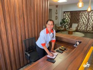 a woman standing at a desk in an office at ORA Beach Residence by AFT in Porto De Galinhas +58 photos