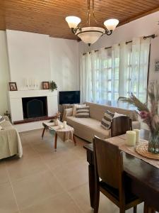 una sala de estar con un sofá y una mesa en Oropos Cozy House, en Néa Palátia