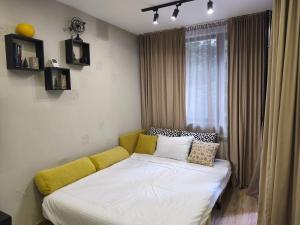 Bett in einem Zimmer mit gelber Couch in der Unterkunft Borovets Gardens Forest STUDIO A3 in Borowez