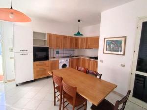 a kitchen with a wooden table and a dining room at Villette Mar Ionio in Nardò