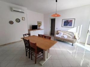a dining room with a table and chairs and a couch at Villette Mar Ionio in Nardò
