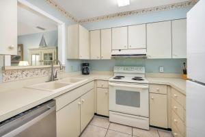 eine Küche mit weißen Schränken und einer Spüle in der Unterkunft Harbour Oaks #403 in Saint Simons Island