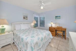 ein Schlafzimmer mit einem Bett, einem Schreibtisch und einem Stuhl in der Unterkunft Harbour Oaks #403 in Saint Simons Island