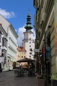 una calle de la ciudad con un edificio con una torre de reloj en Central Apartmany Biela street en Bratislava