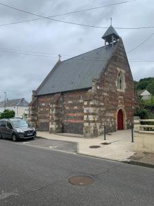 an old brick church with a car parked in front at Petite Maison pleine de charme au Tréport..... in Le Tréport