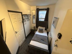 een kleine kamer met twee bedden en een deur bij ONYX Hotel Blackpool in Blackpool