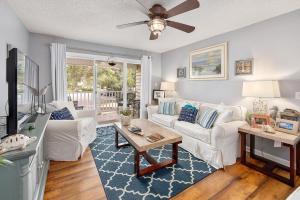 Una sala de estar con muebles blancos y un ventilador de techo. en Ocean Walk D4, en Mallory Park