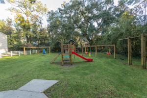 a playground with a red slide in a yard at Ocean Walk A1 in Saint Simons