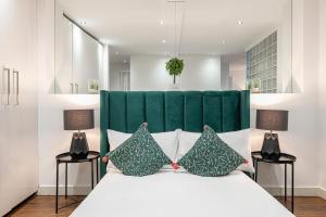 a bedroom with a large white bed with two lamps at Brick Lane Apartments in London