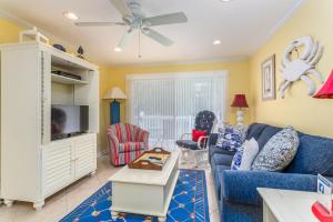 a living room with a blue couch and a tv at Ocean Walk L14 in Saint Simons Island