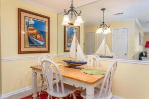 a dining room with a wooden table with a model boat on it at Ocean Walk L14 in Saint Simons Island