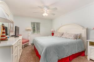 a bedroom with a bed and a ceiling fan at Ocean Walk L14 in Saint Simons Island +20 photos
