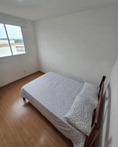 a bed in a white room with a window at Bem-vindo ao seu refúgio em Palhoça in Palhoça