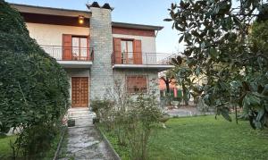 a large brick house with a balcony on a yard at Borgo Caprari in Albinea