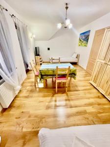 a room with a table and chairs and a couch at Dom na zboczu góry in Brenna
