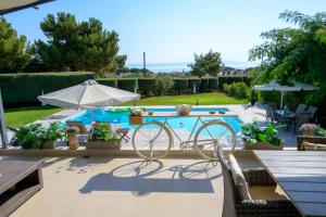 a patio with a table and a bike next to a pool at Mytilini luxury pool VILLA AMIKA in Mytilene