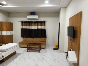 a living room with a couch and a television at Hotel Anmol and Resort in Ghāt Bilod
