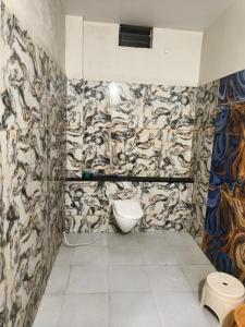 a bathroom with a toilet in a room with wallpaper at Hotel Anmol and Resort in Ghāt Bilod +19 photos