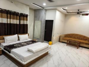 a bedroom with a bed and a couch in it at Hotel Anmol and Resort in Ghāt Bilod