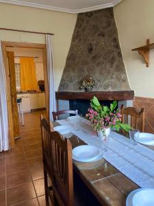 a dining room with a table with plates and flowers at Casa Rural La Abuela Obdulia in Piornal