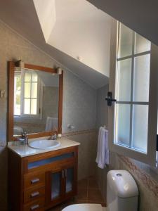 ein Badezimmer mit Waschbecken, Toilette und Spiegel in der Unterkunft Casa Rural La Abuela Obdulia in Piornal