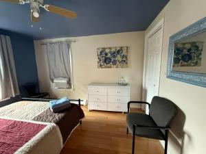 a bedroom with a bed and a chair at Beautiful 2-Bedroom, 2-Bath Townhouse in Boston