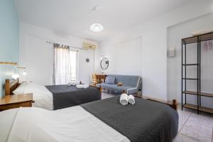 a hotel room with two beds and a couch at Palm Studios, 350m from Agios Sostis Beach, by ZanteWize in Zakynthos Town