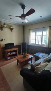ein Wohnzimmer mit einer Couch und einem Deckenventilator in der Unterkunft Casa Rural La Abuela Obdulia in Piornal + 25 Fotos