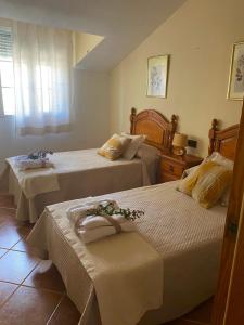 a bedroom with two beds with flowers on them at Casa Rural La Abuela Obdulia in Piornal +24 photos