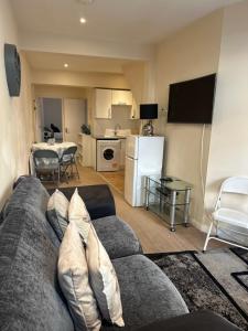 Una sala de estar con un sofá y una cocina. en Eastbourne Beachfront Apartments, en Eastbourne