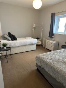 Un dormitorio con dos camas y una mesa y un espejo. en Eastbourne Beachfront Apartments, en Eastbourne