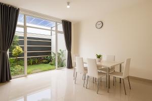 a dining room with a table and chairs and a large window at The Villas in Bogor