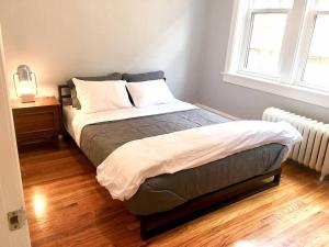 a bedroom with a bed and a night stand and a window at Giraffe Properties in Clayton