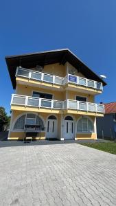 a large yellow building with a patio in front of it at Urban home apartments in Bihać