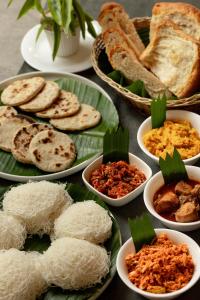 une table avec des assiettes de nourriture avec du riz et du pain dans l'établissement Hotel Avalong by Malwatta, à Kandy 31 autres photos