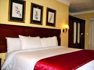 a bedroom with a large white bed with a red blanket at Alexandria Mediterranean Suites in Alexandria