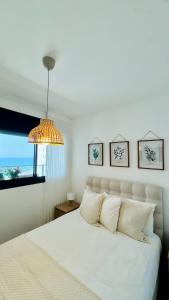a bedroom with a white bed and a window at Blue Bay in Netanya