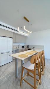 a kitchen with a large white island with chairs at Blue Bay in Netanya