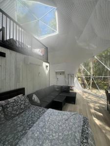 a bedroom with a bed and a couch and a window at Chamcook Dome in Saint Andrews