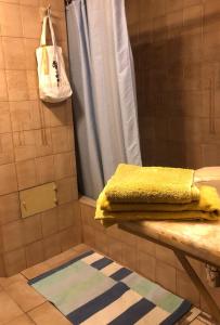 Un baño con toallas amarillas en un estante en una ducha. en DEPARTAMENTO UNA HABITACIÓN con BALCON La Boheme Garden, en Santa Cruz de la Sierra