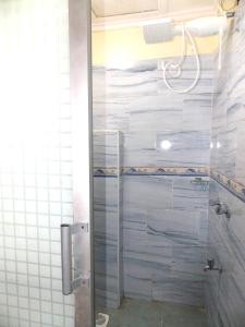 a bathroom with a shower with a glass door at Axis Garden Suites 8-Bedroom Villa Near JKIA & SGR in Syokimau