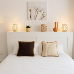 エルドゥヴァンにあるMaison de plage avec piscine Erdeven-Carnacの枕が2つ置かれた白いベッド