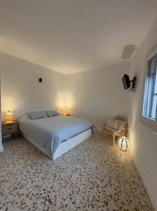 Un dormitorio con una cama y una silla y una ventana. en Casa Pradillo, en Trujillo