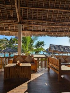 a resort patio with benches and a view of the ocean at Amour Beach Villas in Paje