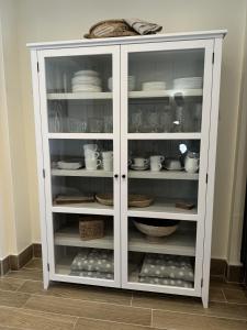 einem weißen Schrank mit Geschirr und Schüsseln in der Unterkunft Trevor Street in Holywood + 12 Fotos