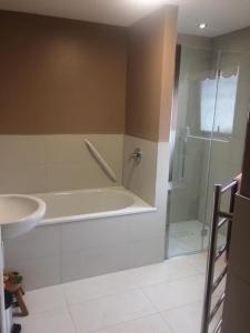 a bathroom with a tub and a shower and a sink at Merrihaven - luxury cottage with sea views in Saint Abbs