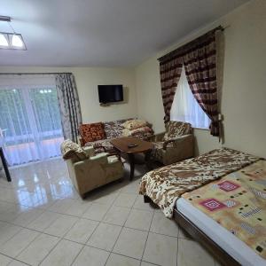 a bedroom with a bed and a couch and a table at dom wczasowy in Orchówek
