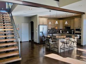 a kitchen with a large island with bar stools at Barnwood Chateau With 2 Master Suites Hot Tub in Salida